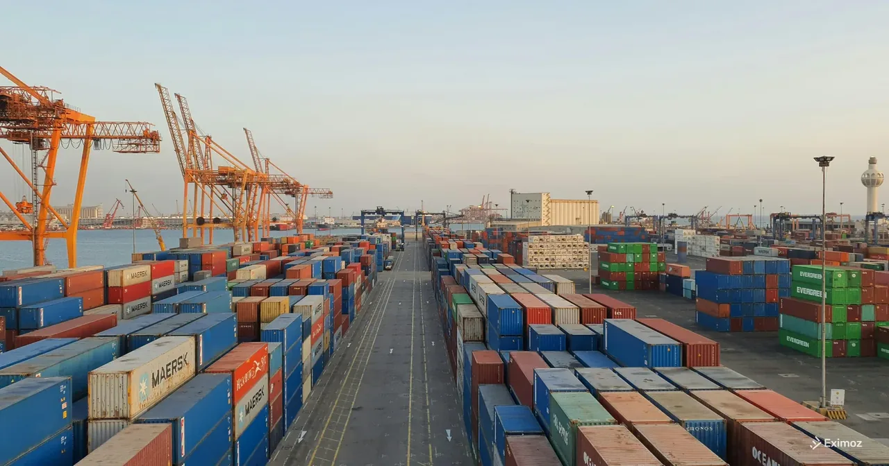 A bustling port scene with colorful cargo containers at sunrise, representing global trade and customs logistics.